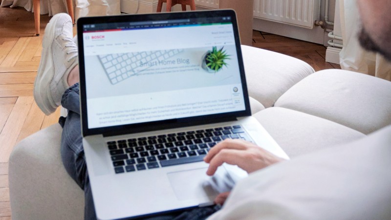 Eine Person mit einem Laptop auf dem Schoß