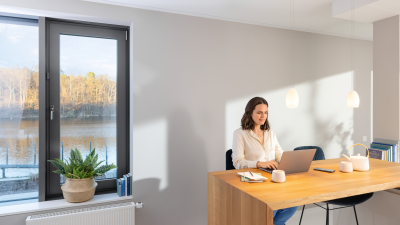 Eine Frau sitzt mit ihrem Laptop am Esstisch