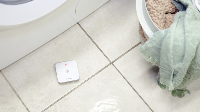 Push-Benachrichtigung mit dem Text: Rauchalarm wurde ausgelöst. Daneben ein Smartphone mit Bosch Smart Home App.