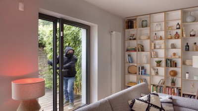 Ein Einbrecher bricht in ein Wohnzimmer ein