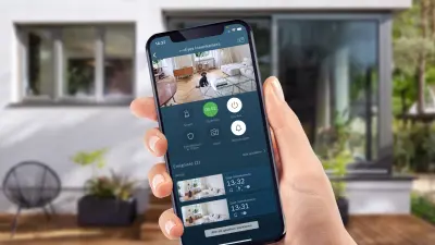 Smartphone zeigt wie Innenkamera den Hund im Wohnzimmer aufnimmt