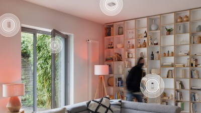 Un cambrioleur dans un salon, avec des produits Bosch Smart Home en arrière-plan