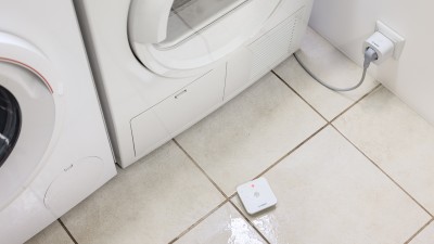 Ein Bosch Smart Home Wassermelder auf nassem Boden