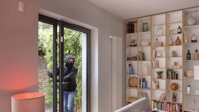 Einbrecher kommt durch die Terassentür mit Tür-/Fensterkontakt ins Wohnzimmer. Lampe leuchtet rot