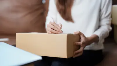 Eine Frau beschriftet ein Paket